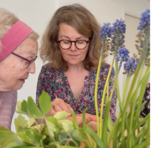 Marianne viser plante til plejehjemsbeboer